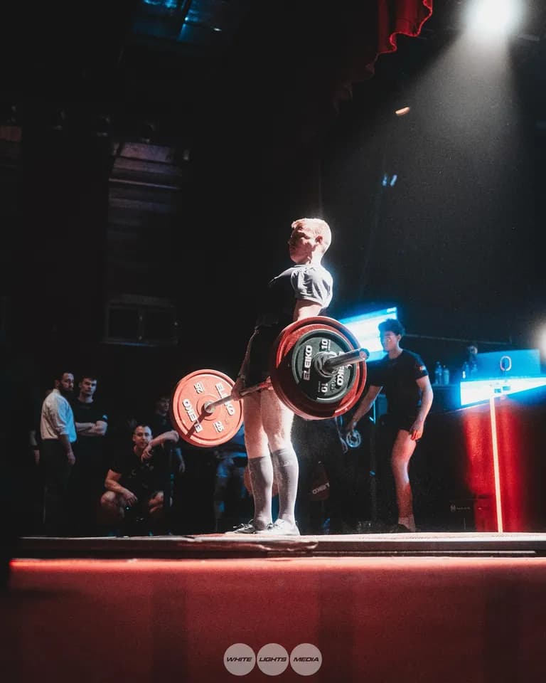 Un athlète exécute un soulevé de terre lors d'une compétition de powerlifting. Photo @quentin_fauche_ / @whitelightsmediafr.