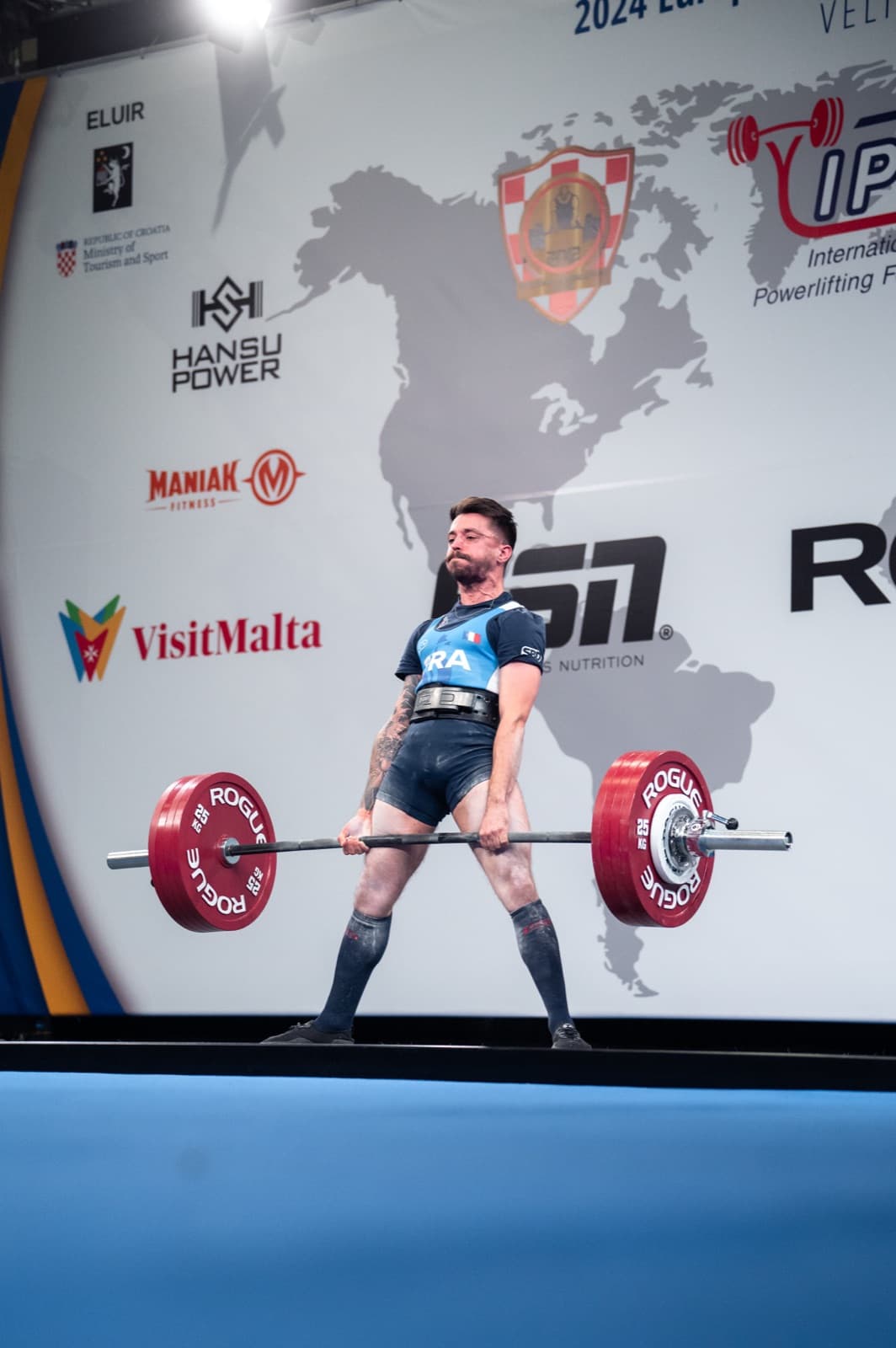 Powerlifter verrouillant un soulevé de terre chargé en compétition internationale. Image du programme Single Split de l’app Sarox.